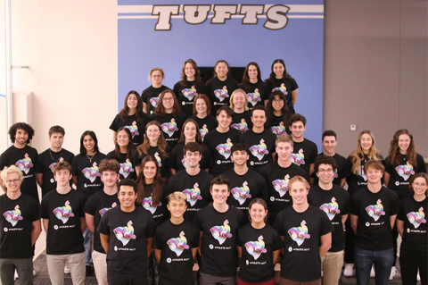 Large group of Tufts students wearing Athlete Ally T-shirts pose for a photo together