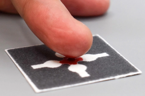 A finger leaving a bit of blood on a piece of paper. Inexpensive, shelf-stable, easy-to-use tests bring lab-level precision to the home and field for blood, water, and lactic acid in sweat tests.