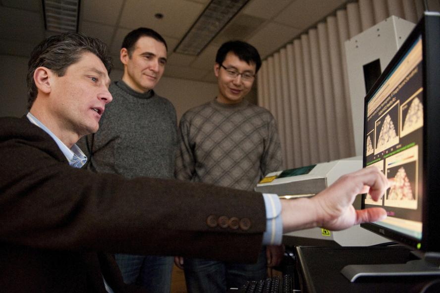 Professor Fantini, Professor Sassaroli, and a student analyzing data on a computer