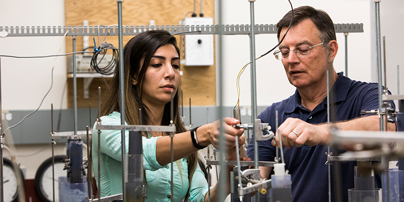 Research Professor of Civil and Environment Engineering  John ("Jack") Germaine and a graduate student, work together on lab equipment.