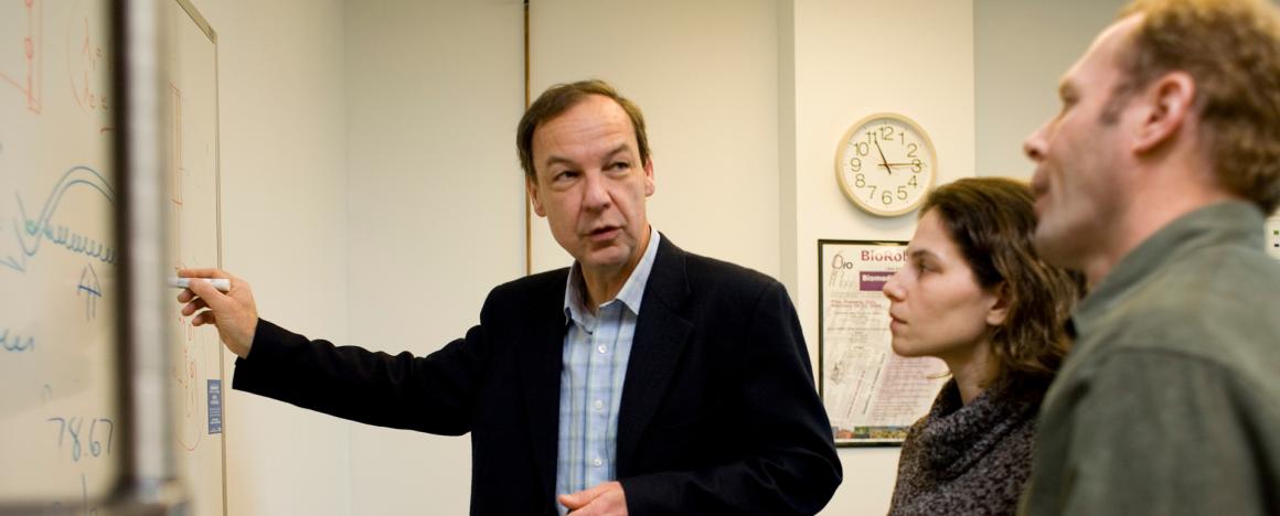 Professor Dorfman teaching in front of a white board