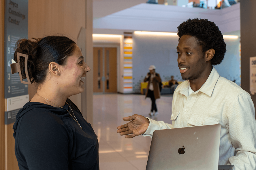 Two students discuss their work in the lobby of Joyce Cummings Center.