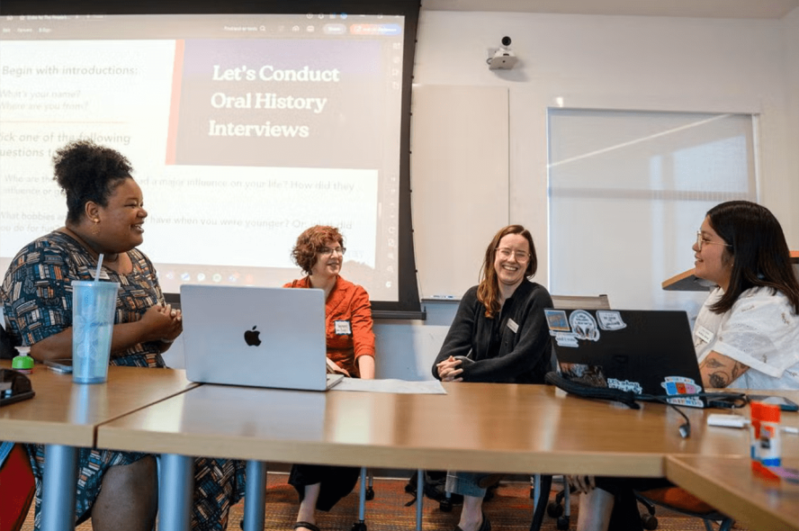 Four people sitting at a table in conversation with one another at the Tisch Librarians workshop during the Tufts University Juneteenth remembrance and celebration on June 18, 2025.