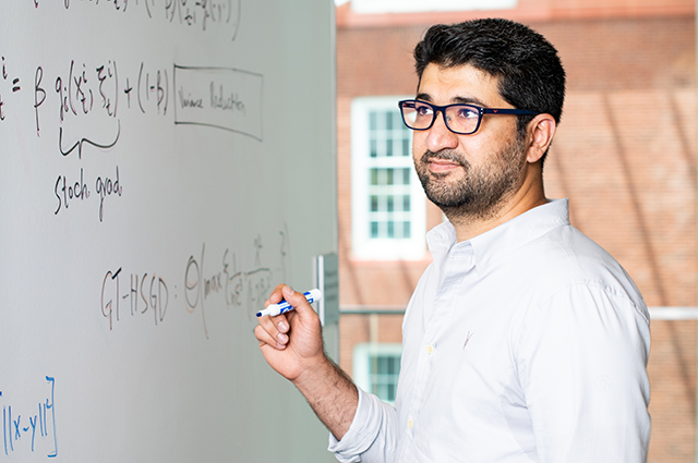 Associate Professor Usman Khan standing at a whiteboard