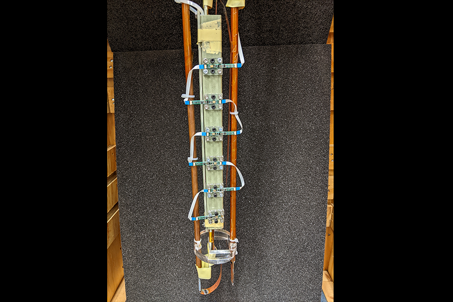 An image of the cyrogenic probe with six MEMS microphone boards assembled into a linear array, ready for testing with a superconducting REBCO tape.