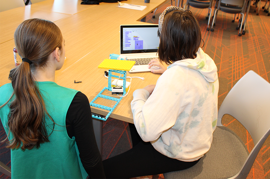 Girl scouts work on designing and building a robot on a recent visit to Tufts. 