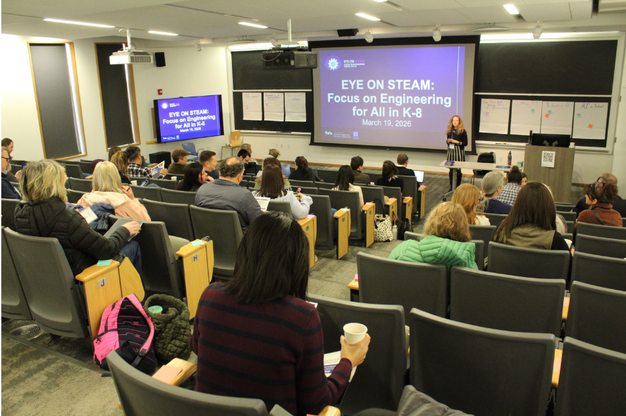 Attendees gather in Robinson Hall for the Eye on STEAM conference. The screen up front reads Eye on STEAM: Focus on Engineering for All K-8.