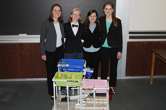 Four mechanical engineering majors pose with their educational water table.