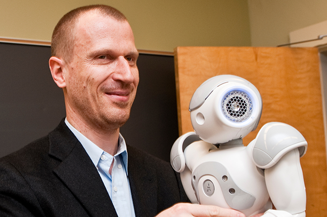 A man's face next to a robot head.