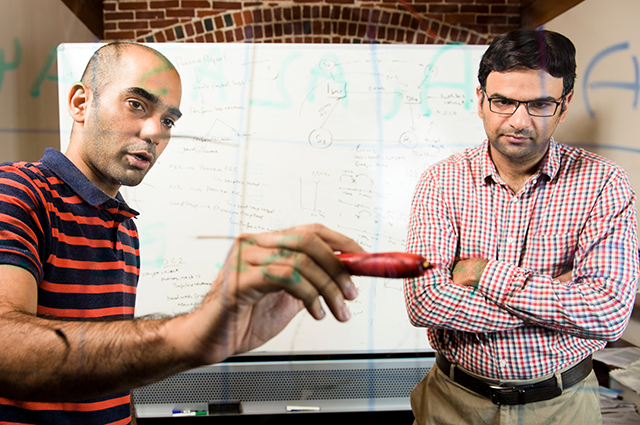 Assistant Professor Fahad Dogar and Ph.D. candidate Osama Haq looking at equations together