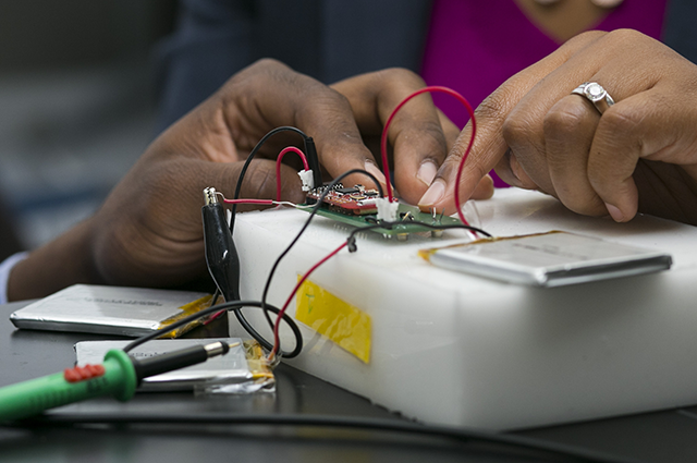 Valencia Koomson and Nana Kwakwa's hands on a on-invasive, wearable device to measure blood oxygenation in the brain
