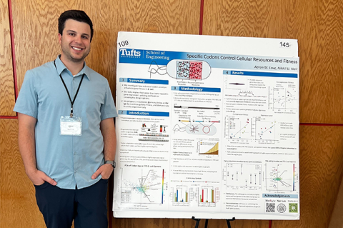 PhD student Aaron Love stands next to his winning poster at the Boston Bacterial Meeting.
