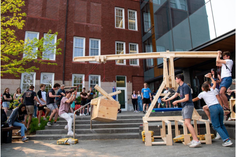 Students in the Mechanical Engineering Design for Fabrication class test their wooden cranes on the patio at the Science and Engineering Complex on May 8. 