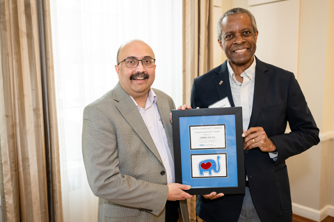 Tufts University President Sunil Kumar presents the Tufts Community Grants Sustaining Partner Award to Chris Swan.