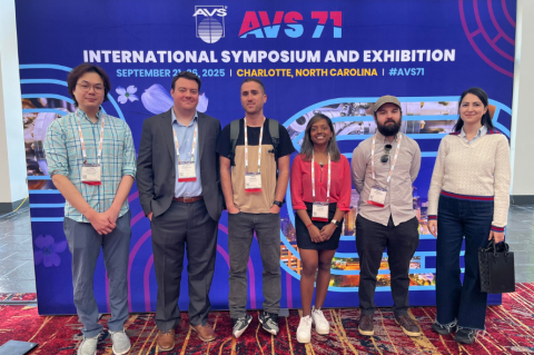A group of people standing in front of a banner that says international symposium and exhibition