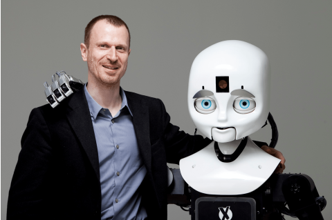 Professor Matthias Scheutz with his team's robot, "Cindy," in the Human Robot Interaction Lab