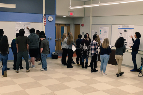 Tufts graduate students present their research to students at Medford High School.