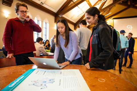From left, Alex Johnson, a project manager with JumboCode, shares the new website his team built for Tufts’ Ears for Peers with his client Heather Mei, and her friend Avni Rajpal. Photo: Anna Miller