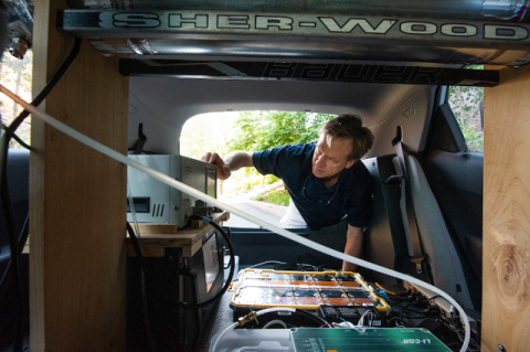 John Durant checks equipment in the mobile Tufts Air Pollution Monitoring Lab.