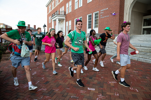 Students with toy hats race through the campus.