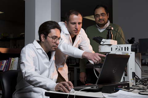 Three researchers looking at a computer together