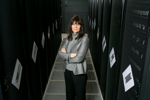 Professor Kathleen Fisher stands in a computer data center.