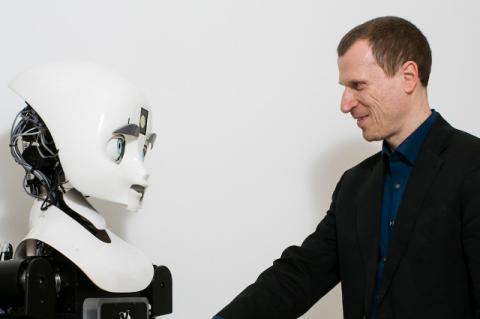 Matthias Scheutz models Human-Robot Interaction with a robot.
