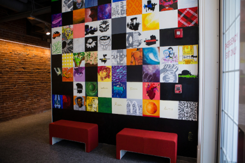 A colorful mural made up of many small squares, each featuring a different subject.